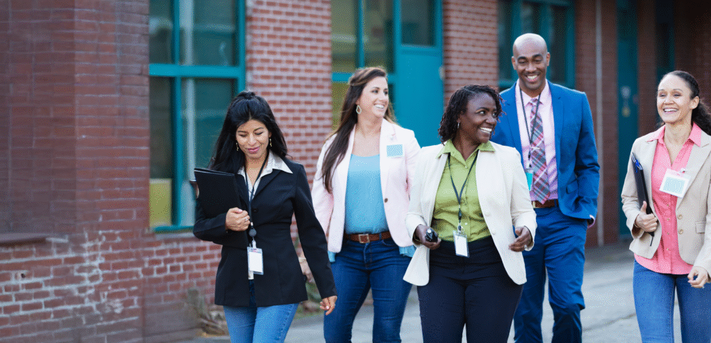 group of teachers outside of their k-12 public school in New York, discussing educational leadership coaching